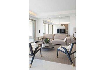 A living room with a couch and two chairs