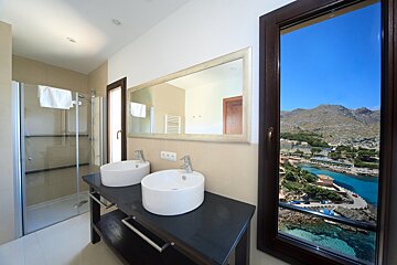 A bathroom with two sinks and a view of the ocean