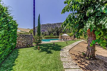 A stone walkway leads to a large swimming pool