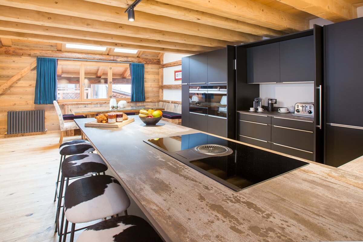 A kitchen with black cabinets and a stove top oven