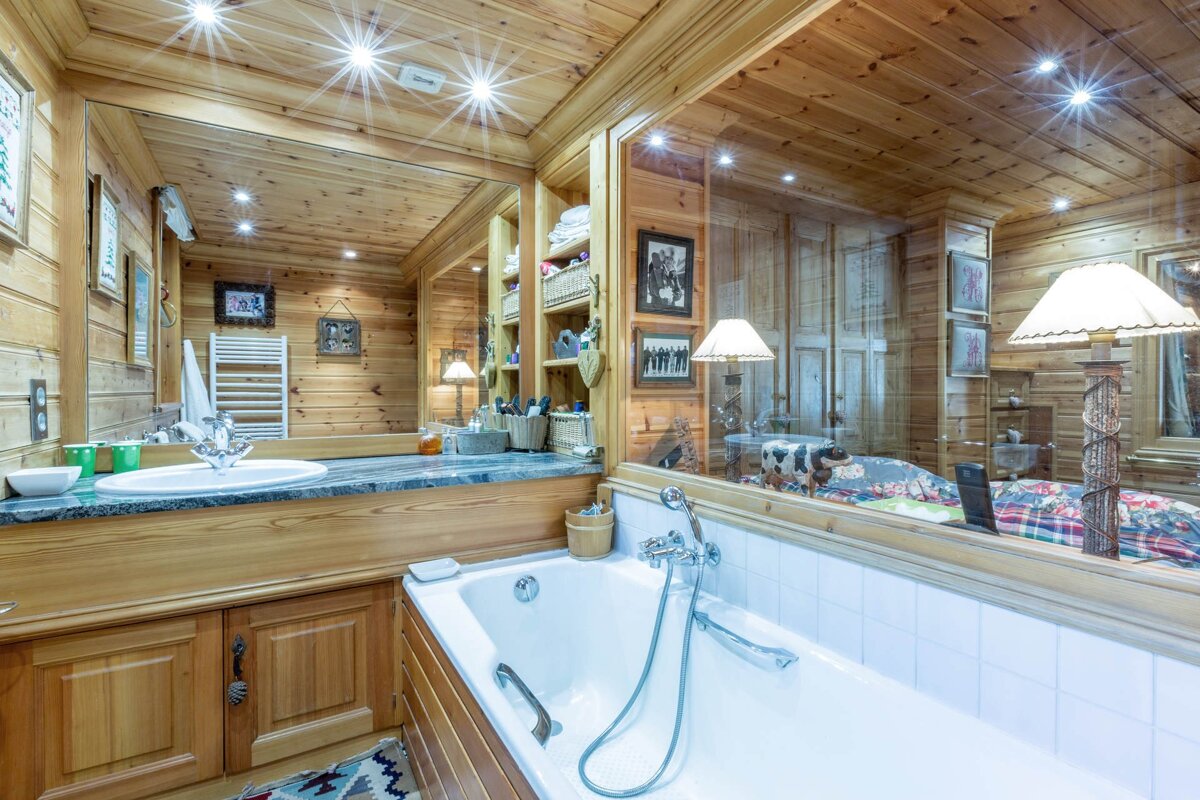 A bedroom with a bed and a bathroom behind it