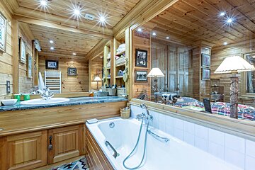 A bedroom with a bed and a bathroom behind it