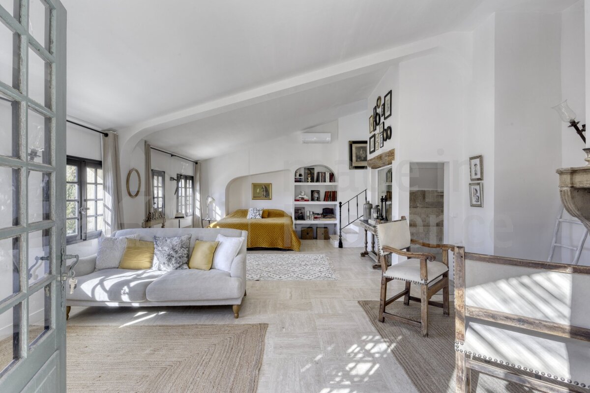 A living room with a white couch and a yellow bed