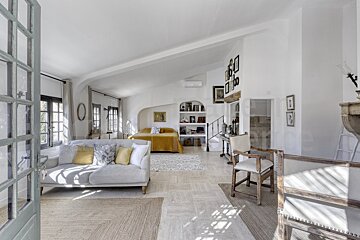 A living room with a white couch and a yellow bed