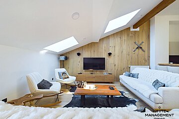 A living room with white management written on the bottom