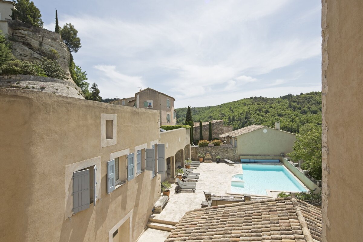 A large house with a swimming pool in front of it