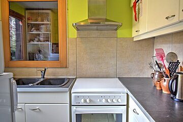 A kitchen with a stove top oven and a sink