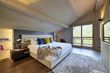 A bedroom with a large bed and a large window