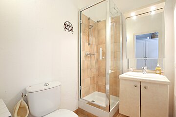 A bathroom with a toilet a sink and a shower