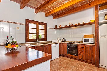 A kitchen with wooden cabinets and a microwave