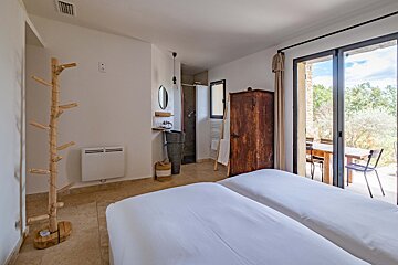 A bedroom with two beds and a sliding glass door