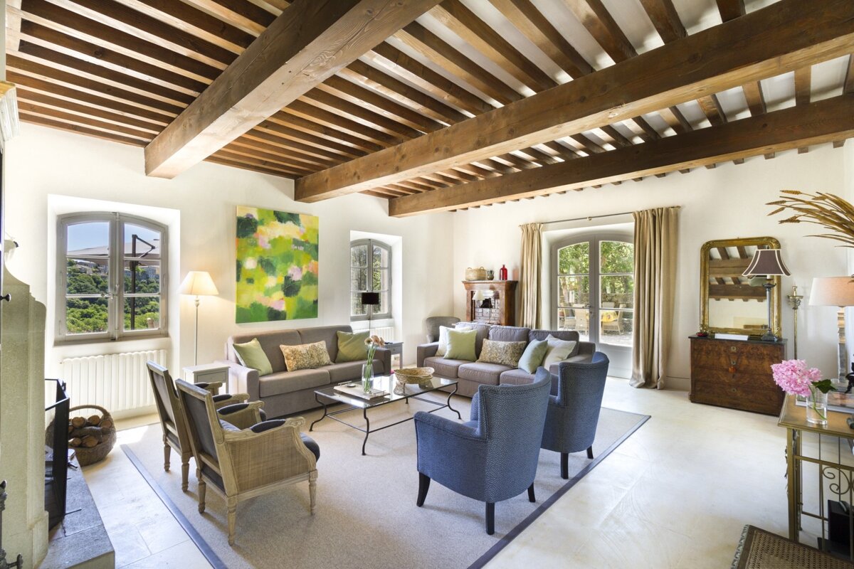 A living room with a painting on the wall above the couch