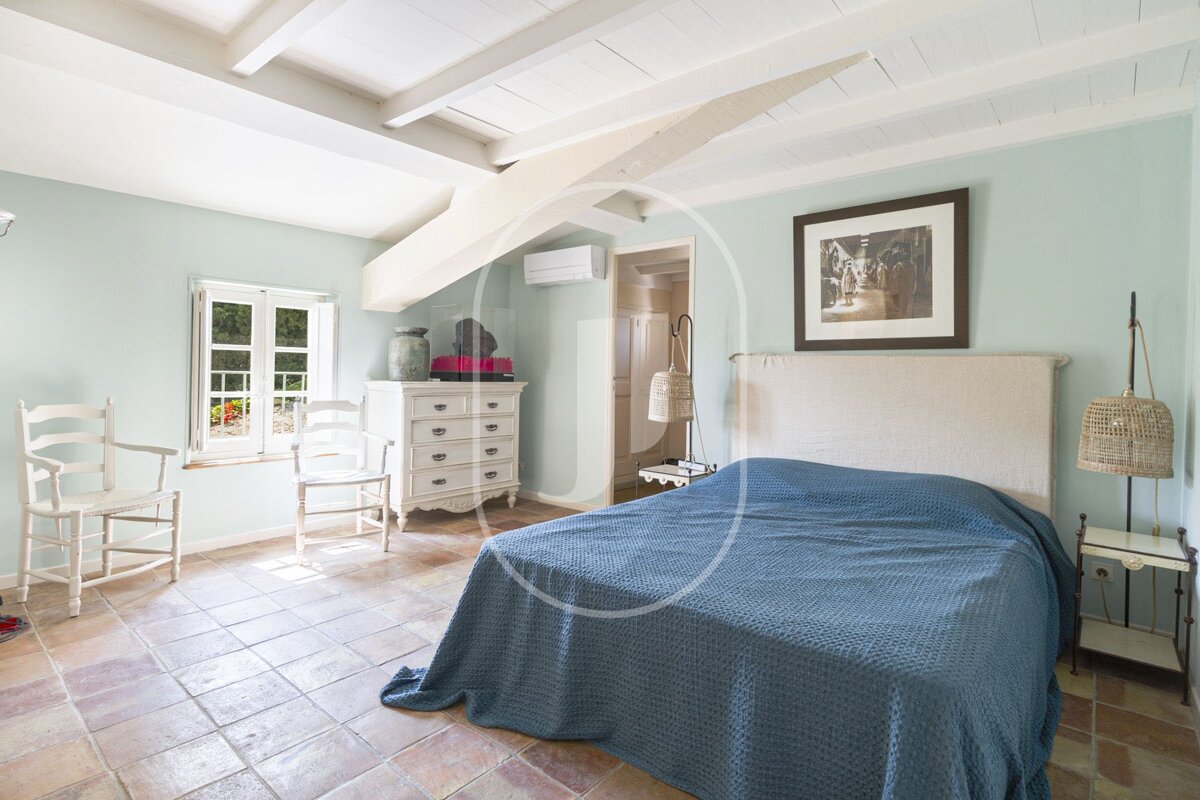 A bedroom with a blue bed and a picture on the wall