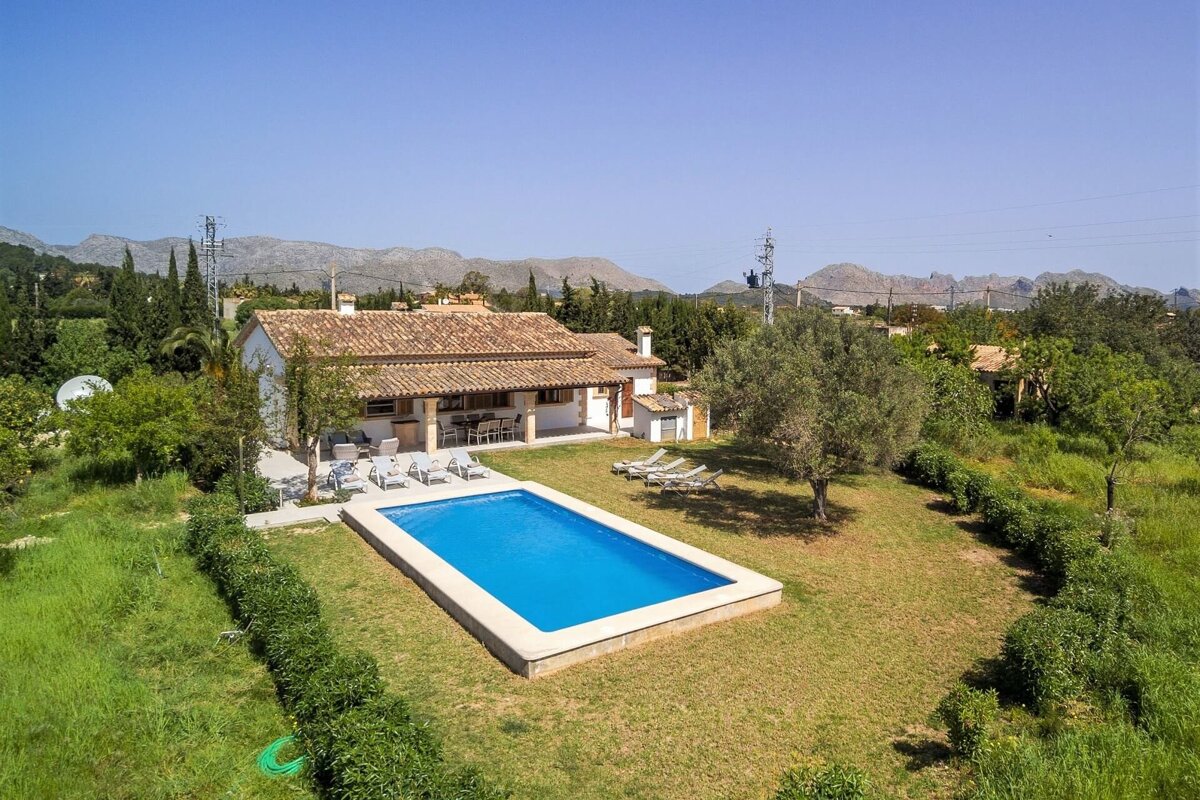 An aerial view of a house with a large swimming pool