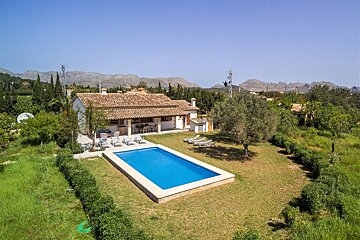 An aerial view of a house with a large swimming pool