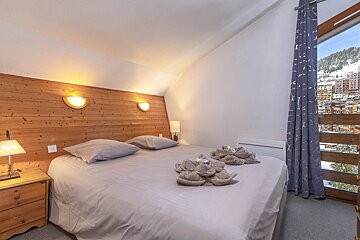 A bedroom with a large bed and two lamps