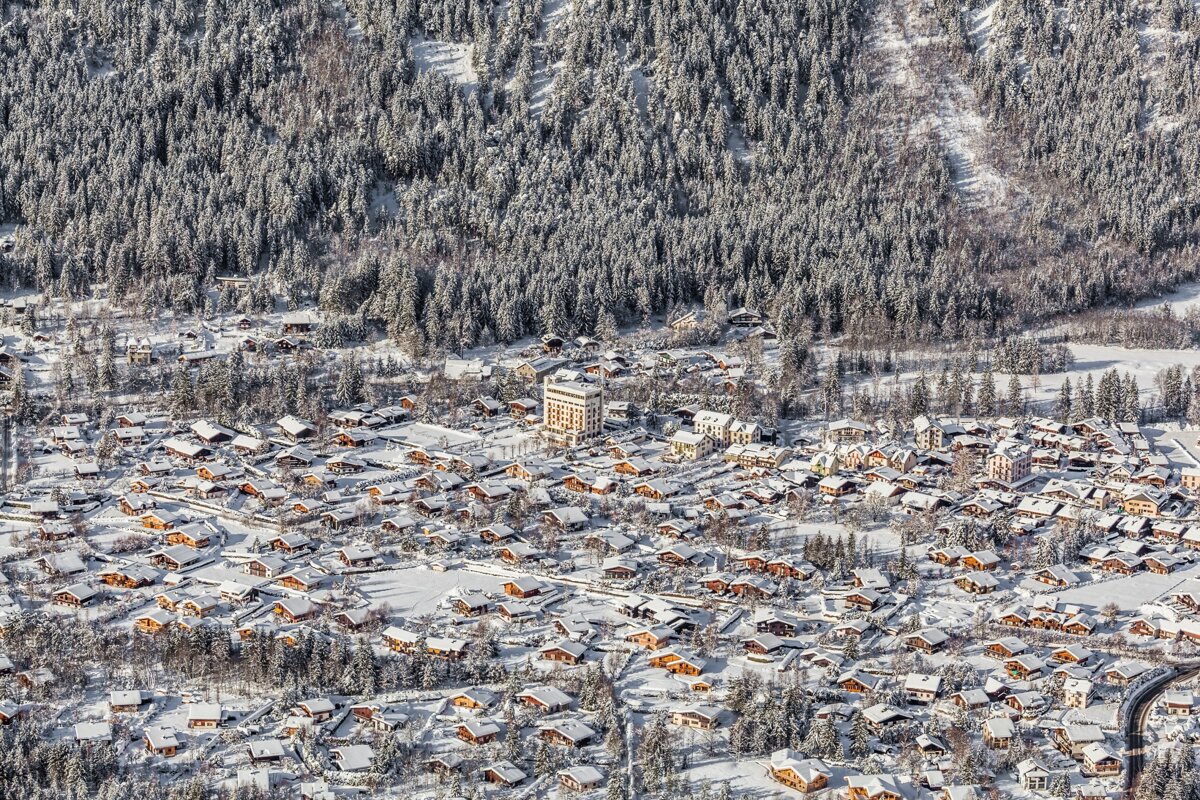 An aerial view of a snow covered village in the mountains