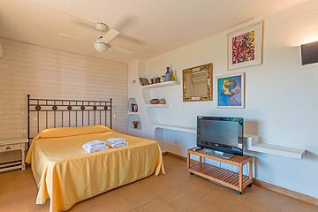 A bedroom with a bed and a flat screen tv