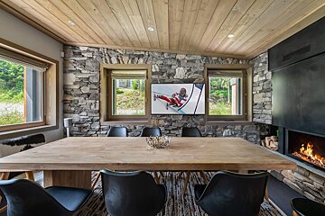 A dining room with a wooden table and black chairs