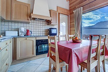 A kitchen with wooden cabinets and a red table cloth