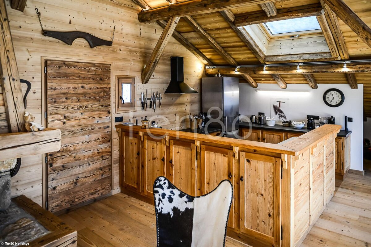 A kitchen with wooden cabinets and a cow print chair