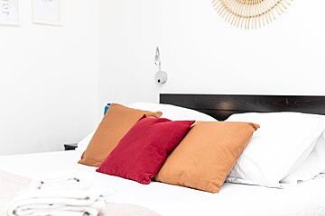 A bed with white sheets and three pillows on it