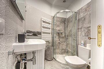 A bathroom with a toilet a sink and a shower