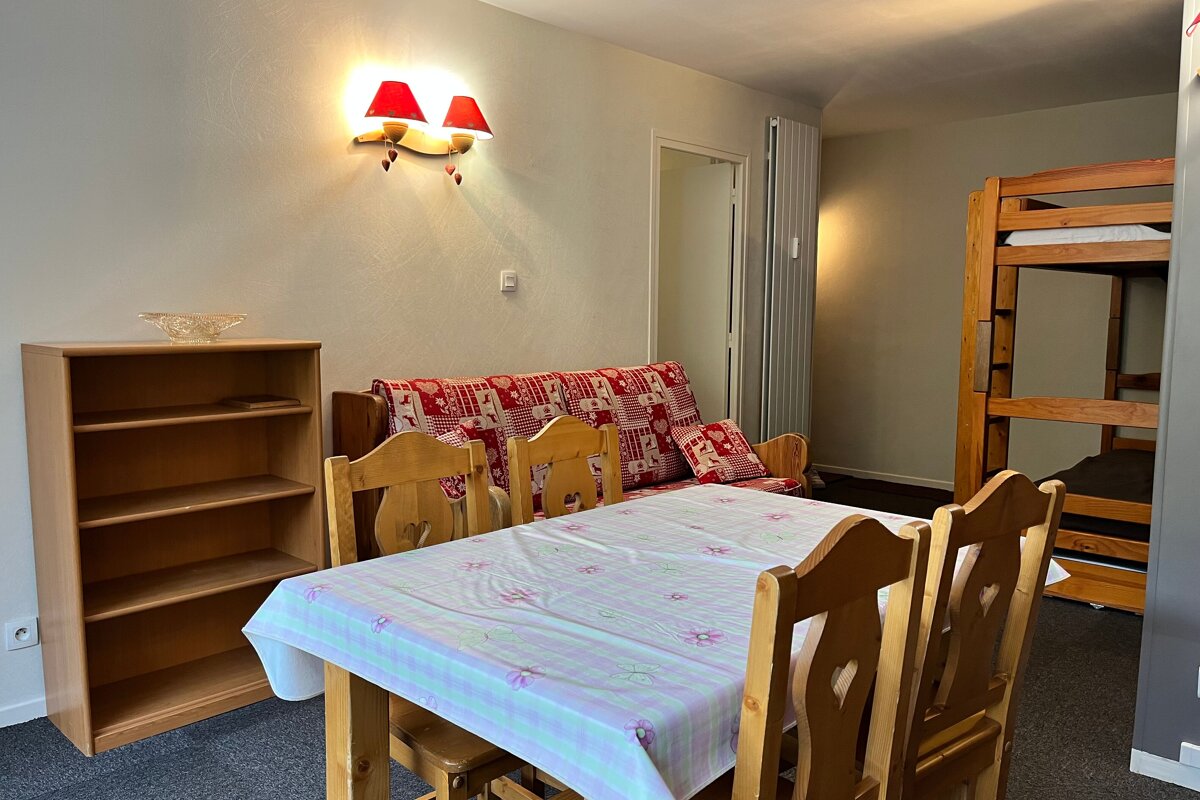 A table and chairs in a room with bunk beds