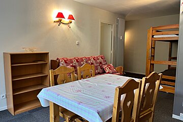 A table and chairs in a room with bunk beds