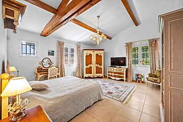 A bedroom with a bed dresser and television