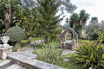 A stone well sits in the middle of a lush green garden