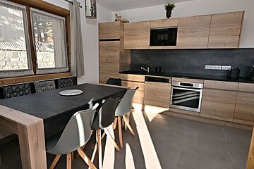 A kitchen with a table and chairs and a coca cola blanket