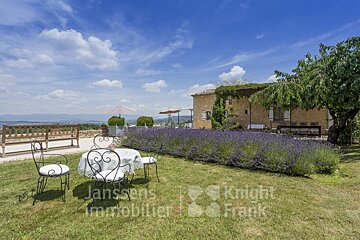 A lawn with a table and chairs and a sign that says janssens immobilier