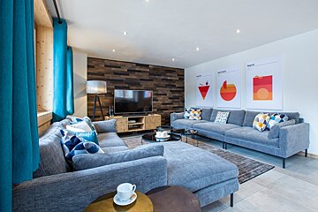 A living room with a large sectional couch and a flat screen tv