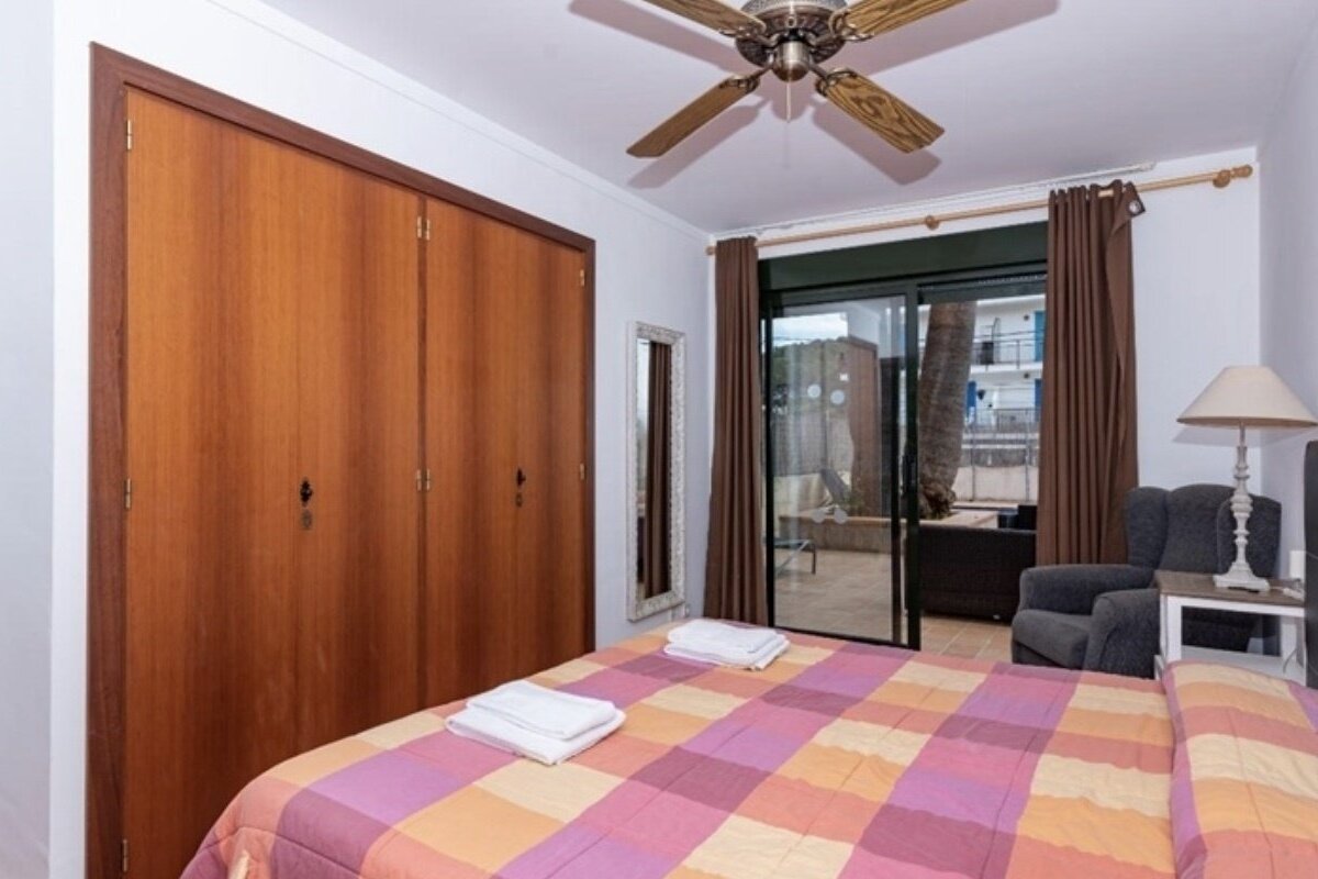 A bedroom with a large bed and a ceiling fan