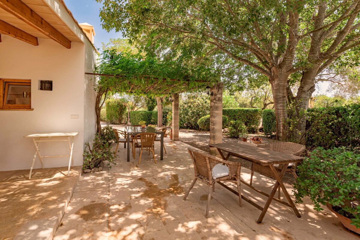 A patio with a table and chairs under a pergola