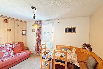 A living room with a table and chairs and a chalkboard on the wall