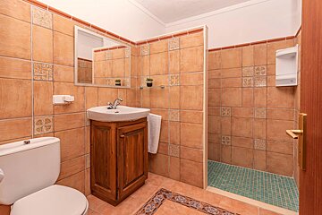 A bathroom with a toilet sink and a walk in shower