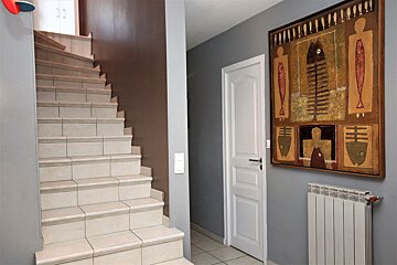 A staircase with a painting on the wall above it