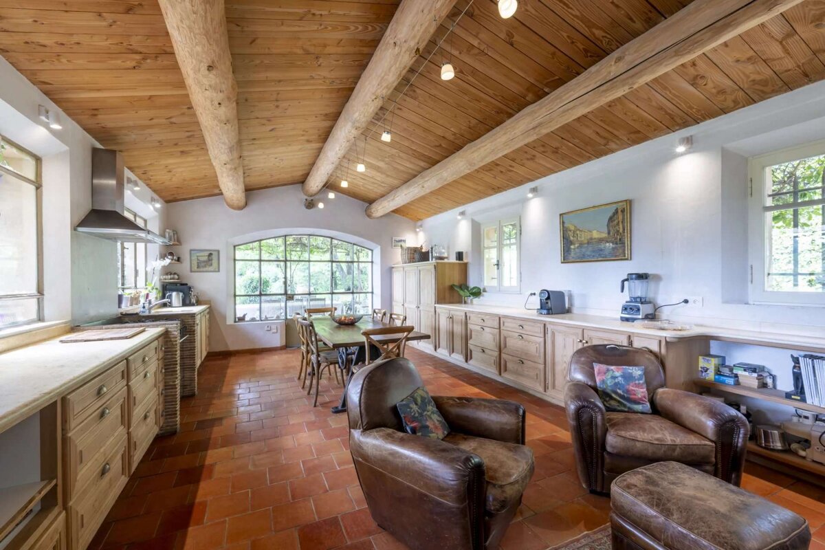 A kitchen with a table and chairs and a painting on the wall