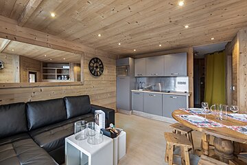 A living room with a clock on the wall above the couch