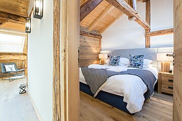 A bedroom with a bed and a chair in it