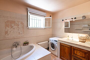 A bathroom with a washing machine and a bathtub