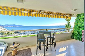 A balcony with a view of the ocean and mountains