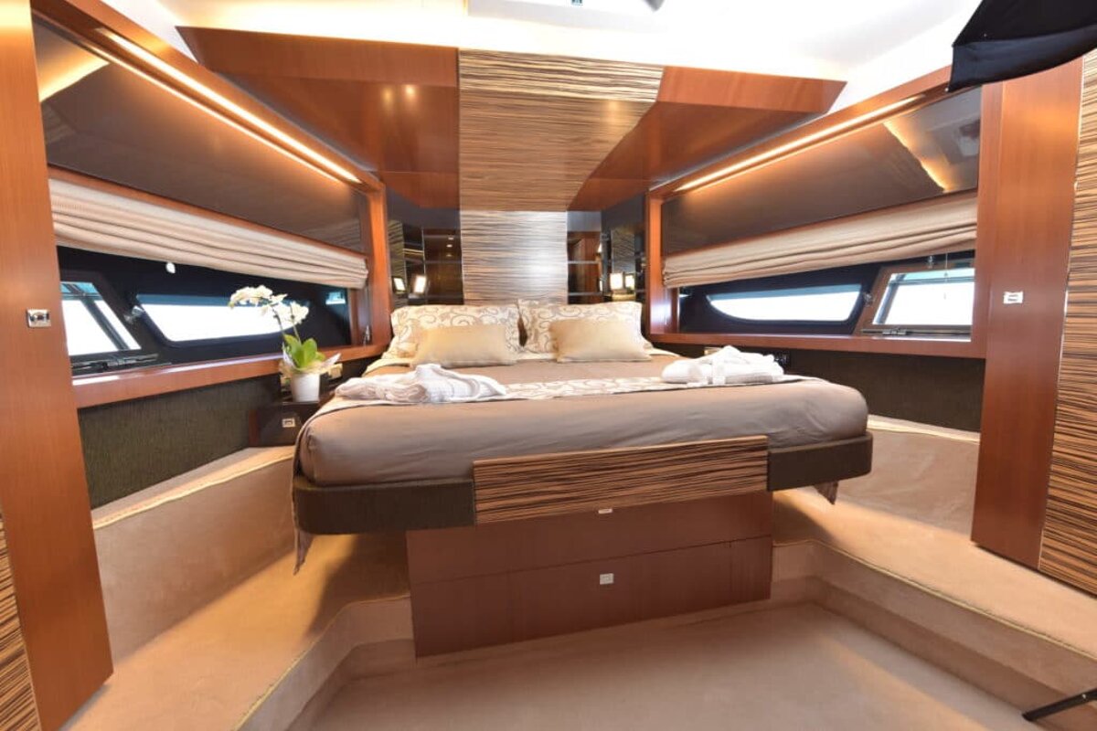 A bedroom on a boat with a bed and a window