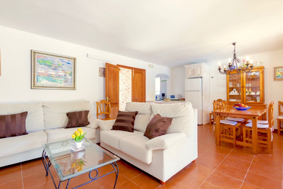 A living room with a white couch and brown pillows