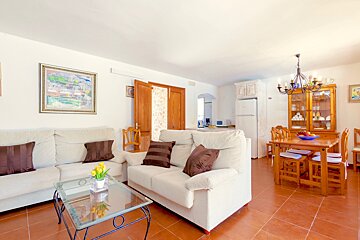A living room with a white couch and brown pillows