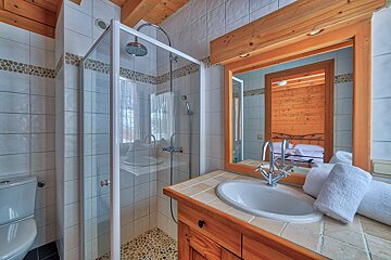 A bathroom with a walk in shower and a sink