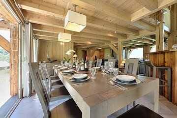 A dining room table with a bottle of wine on it