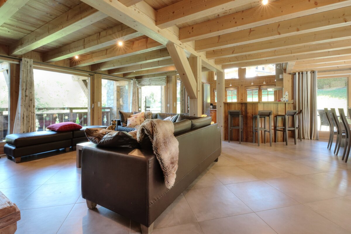 A living room with a black couch and a blanket on it